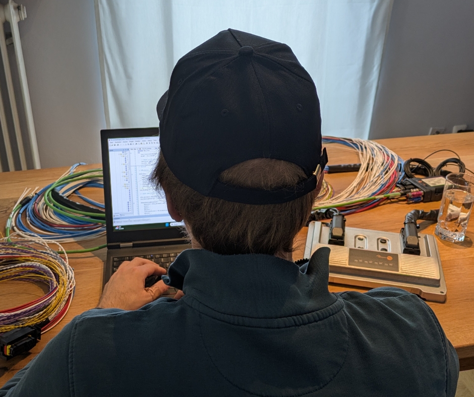 Mitarbeiter der technischen Entwicklung arbeitet an Software und Kabelsystemen des TADUS Traktors.