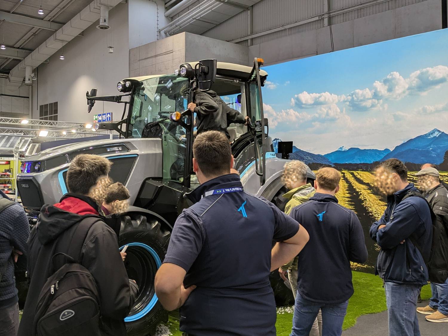 Zu sehen ist der Prototyp des TADUS T16.20 auf der Messe AgriTechnica 2025. Er steht vor einer Feldlandschaft auf Kunstgras. Die Besucheranzahl ist hoch.