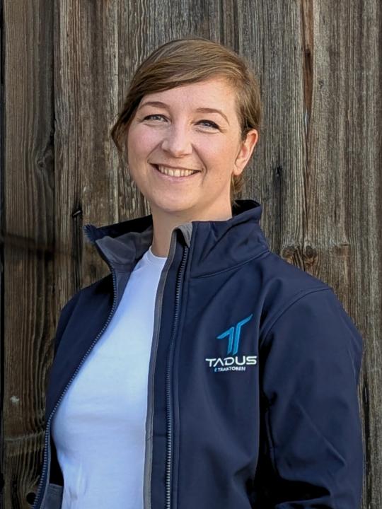 Das Bild zeigt die Geschäftsführung der TADUS GmbH im Portrait. Der Hintergrund ist eine Holzwand.