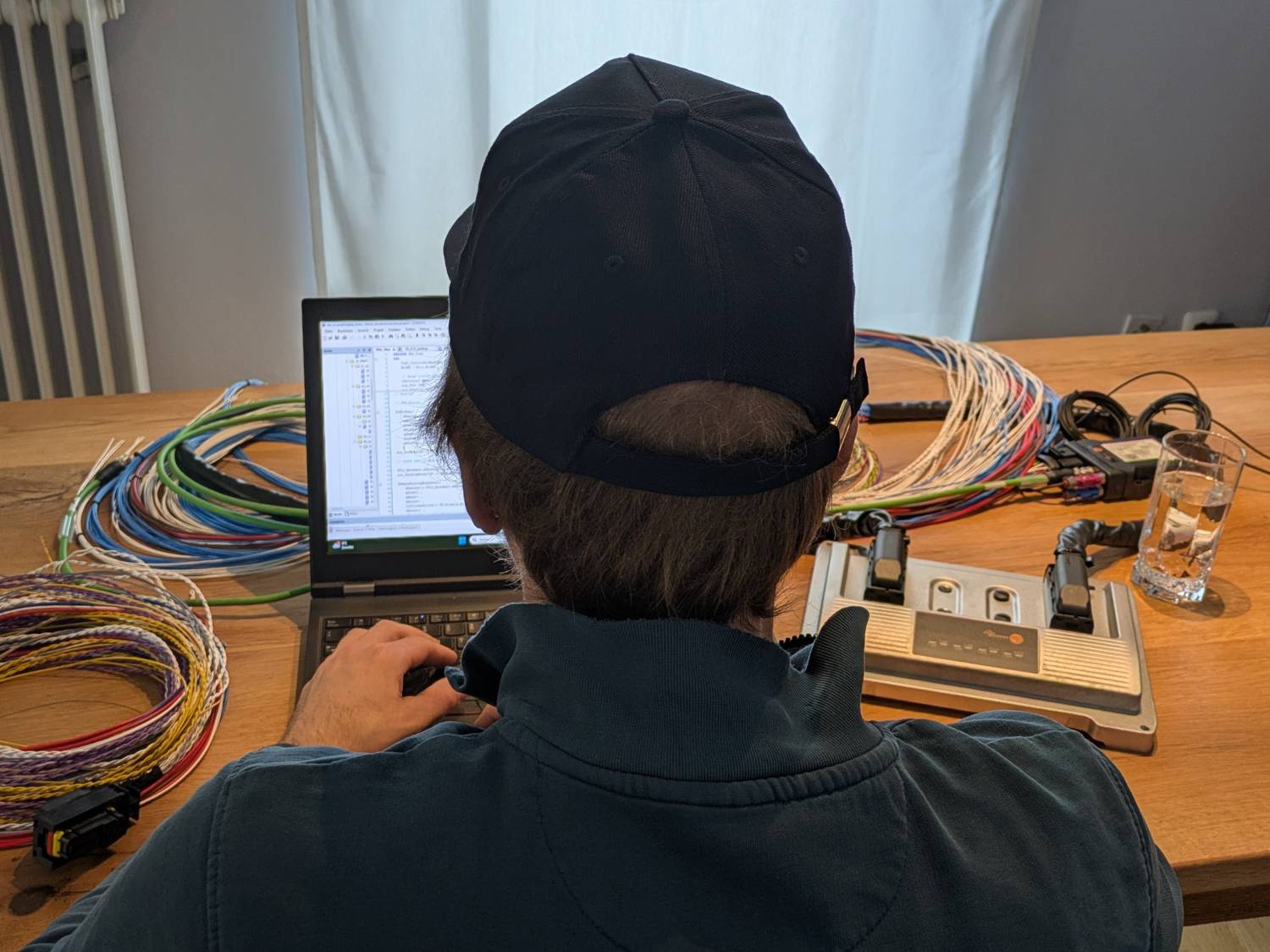 Mitarbeiter der technischen Entwicklung arbeitet an Software und Kabelsystemen des TADUS Traktors.